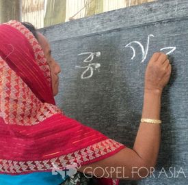 Neela practices her newly learned writing skills during the Women’s Fellowship literacy class.