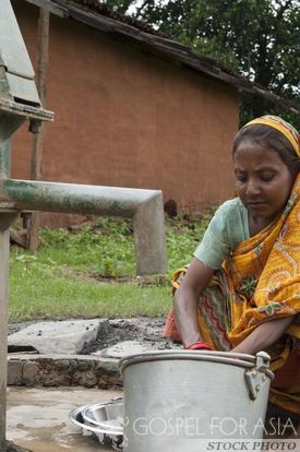 Woman washing dishes at a Jesus Well - Gospel for Asia - KP Yohannan