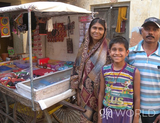 Recipients of a GFA gift distribution stand with their pull cart.