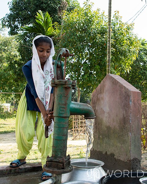 woman gets clean water from the new Jesus Well in her village.