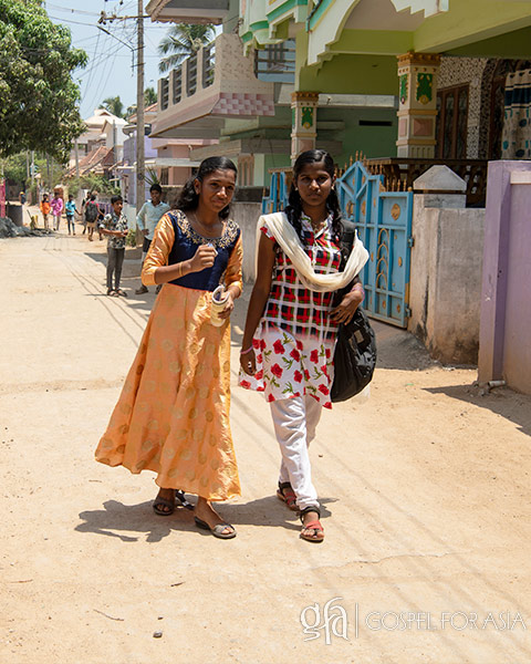 two girls walk down street