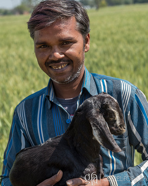 happy man smiles with goat