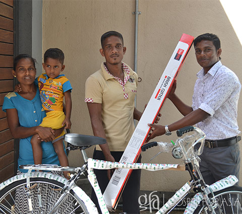 Couple receives bicycle and grass-cutting gear