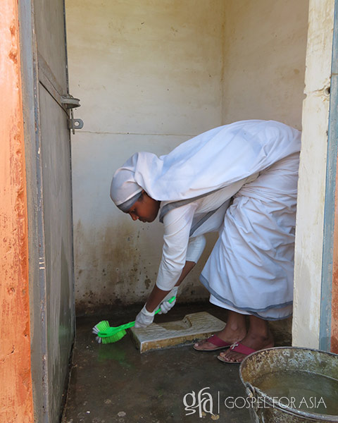 Sister of Compassion cleaning a toilet