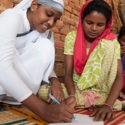 A GFA World Sister of Compassion helps teach a woman how to read and write.