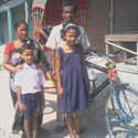 Man pictured with his family and the rickshaw he was given from GFA World.
